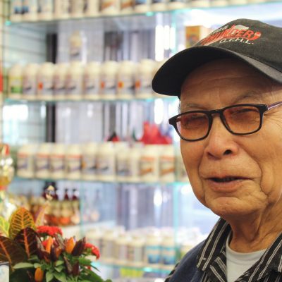 old man wearing hat at herbal store