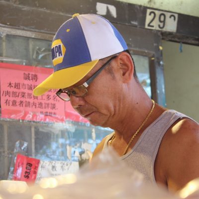 man in hat working at grocery store, looking down
