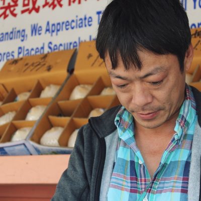 man working at grocery store looking down
