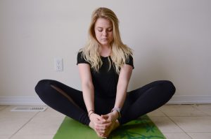 Far shot of woman holding feet together