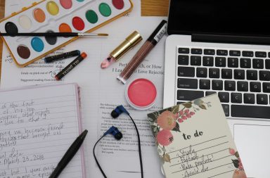 Picture of school notes, laptop, art supplies and make up products.